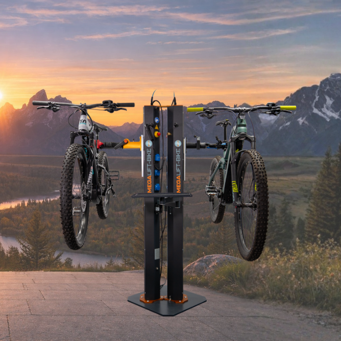 Electric bike repair stand with two workstations holding mountain bikes in scenic mountain landscape at sunrise